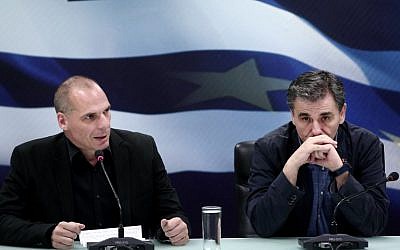 Outgoing Finance Minister Yanis Varoufakis (L) speaks next to newly appointed Greek Finance Minister Euclid Tsakalotos (R) during a handover ceremony at the Finance Ministry in Athens on July 6, 2015. AFP PHOTO / ANGELOS TZORTZINIS