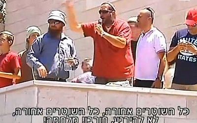 A man whips up the crowd of protesters at Beit El on July 29, 2015 (Channel 2 screenshot)