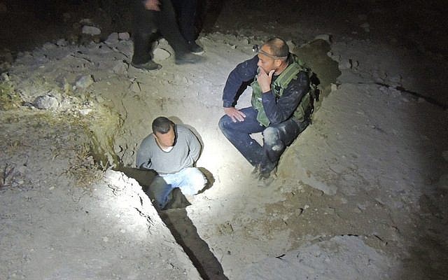 A man suspected of illegal excavation at an antiquities site in Jerusalem is shown handcuffed alongside inspectors, Wednesday, July 8, 2015 (Israel Antiquities Authority) A man suspected of illegal excavation at an antiquities site in Jerusalem is shown handcuffed alongside inspectors, Wednesday, July 8, 2015 (Israel Antiquities Authority)