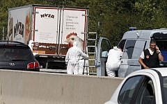 Forensic officers stand in front of a truck inside which were found a large number of dead migrants on a motorway near Neusiedl am See, Austria, on August 27, 2015 (AFP/DIETER NAGL)