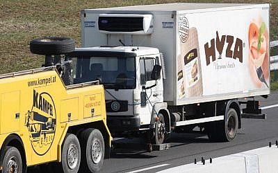 A refrigerated truck is towed along a highway near Neusiedl am See, Austria, on August 27, 2015. (AFP/Dieter Nagl)