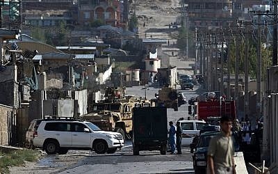 International and Afghan security forces inspect damage outside Camp Integrity, a base housing US special forces that was attacked by militants, in Kabul on August 8, 2015. (AFP PHOTO/WAKIL KOHSAR)