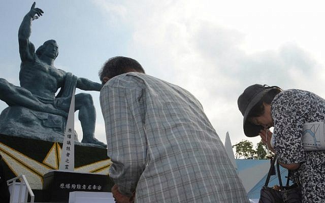 People offer prayers for victims of the World War II atomic bombing of Japan at the Peace Statue in Nagasaki on August 9, 2015. (AFP Photo/Jiji Press)