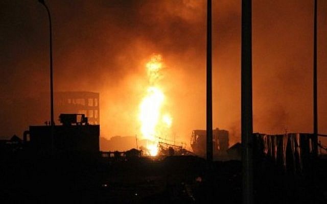 Flames rise next to damaged buildings at the site of an explosion in Tianjin early on August 13, 2015. (AFP) Flames rise next to damaged buildings at the site of an explosion in Tianjin early on August 13, 2015. (AFP)