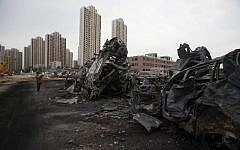 A man takes a photo of damaged cars at the site of the explosions in Tianjin on August 14, 2015.  Enormous explosions in a major Chinese port city killed at least 85 people and injured hundreds more, according to state media (AFP PHOTO)