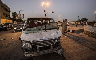 Egyptian policemen (R) stand next to a damaged car in front of a damaged national security building after a bomb blast in northern Cairo's district of Shubra on August 20, 2015.  (AFP  / KHALED DESOUKI)