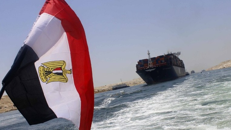 An Egyptian flag flutters as a container ship crosses the new waterway of the Suez canal on July 23, 2015, in the Egyptian port city of Ismailia, east of Cairo (AFP/STR)