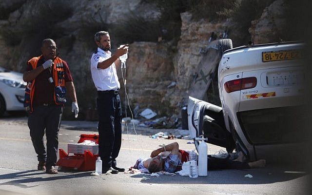 Israeli medics treat one of three soldiers wounded in a car attack at a junction in the West Bank on August 6, 2015. (AFP PHOTO/STR) Israeli medics treat one of three soldiers wounded in a car attack at a junction in the West Bank on August 6, 2015. (AFP PHOTO/STR)