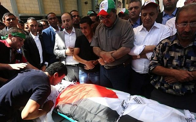 Palestinian men pray over the body of Saad Dawabsha, the father of a Palestinian toddler killed last week when their home was firebombed by Jewish extremists, during his funeral in the West Bank village of Duma on August 8, 2015. (AFP/ JAAFAR ASHTIYEH)