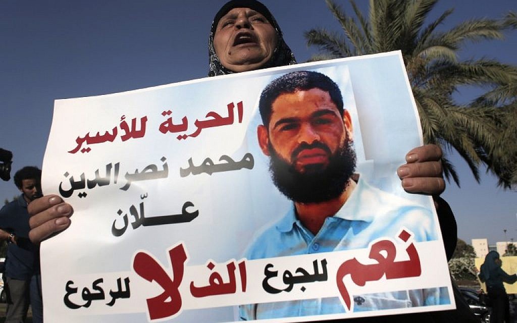 Maazouze, the mother of Mohammed Allaan, a Palestinian prisoner who was on a long-term hunger strike, holds a portrait of her son during a rally calling for his release in the southern Israeli city of Beersheba on August 9, 2015. (AFP/Ahmad Gharabli)