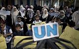 Palestinian children and teachers hold placards during a protest against the reduction of educational programs given by the United Nations Relief and Works Agency at the Rafah refugee camp in the southern Gaza Strip, August 15, 2015. (AFP /SAID KHATIB)