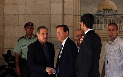 Nabil Abu Rudeineh (L), spokesman of Palestinian Authority president Mahmoud Abbas, welcomes Israeli opposition head Isaac Herzog (C) at the Palestinian Authority headquarters in the West Bank city of Ramallah, August 18, 2015. (AFP Photo/Abbas Momani)