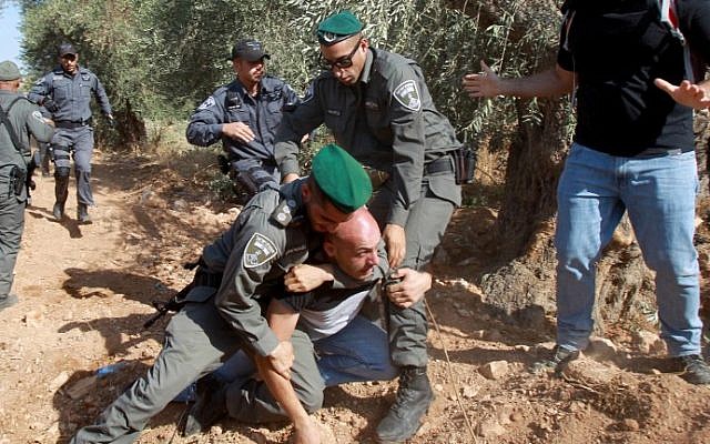 Israeli border police arrest a Palestinian protester who was trying to reach tractors working on the construction of Israel's controversial barrier in the Cremisan Valley, which lies between Jerusalem and Beit Jala, August 19, 2015. (AFP Photo/Musa Al Shaer) Israeli border police arrest a Palestinian protester who was trying to reach tractors working on the construction of Israel's controversial barrier in the Cremisan Valley, which lies between Jerusalem and Beit Jala, August 19, 2015. (AFP Photo/Musa Al Shaer)