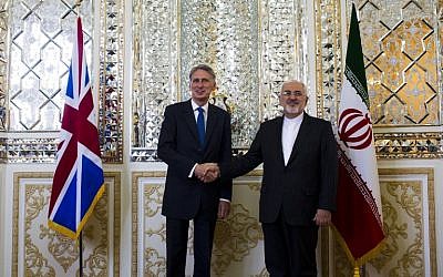 Iranian Foreign Minister Mohammad Javad Zarif (R) shakes hands with his British counterpart Philip Hammond prior to their joint press conference in Tehran on August 23, 2015. (AFP PHOTO/BEHROUZ MEHRI)
