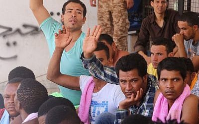 Migrants rescued by Libyan coastguard after their boat sank on August 28, 2015, sit in a security center between the coastal cities of Subrata and Zuwara, west of the capital Tripoli. (AFP PHOTO/MAHMUD TURKIA)