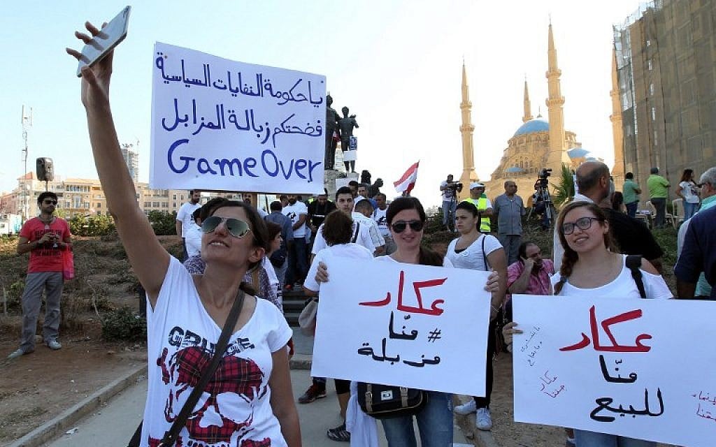 Lebanese young women take pictures as they hold placards before the start of an anti-government protest organised by a civil society frustrated with a political class they see as corrupt and incapable of providing basic services on August 29, 2015 at Beirut's iconic Martyrs Square. (AFP/ ANWAR AMRO) Lebanese young women take pictures as they hold placards before the start of an anti-government protest organised by a civil society frustrated with a political class they see as corrupt and incapable of providing basic services on August 29, 2015 at Beirut's iconic Martyrs Square. (AFP/ ANWAR AMRO)