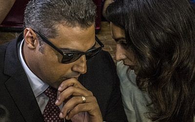 Al-Jazeera journalist, Canadian Mohamed Fahmy (L), accused along with Egyptian Baher Mohamed of supporting the blacklisted Muslim Brotherhood in their coverage for the Qatari-owned broadcaster, talks to human rights lawyer representing him, Amal Clooney (R), during their trial in the capital Cairo on August 29, 2015.(AFP PHOTO / KHALED DESOUKI)