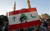 A Lebanese protester raises a placard during a mass rally against a political class seen as corrupt and incapable of providing basic services on August 29, 2015, at the iconic Martyrs Square in Beirut. (AFP PHOTO / STR)