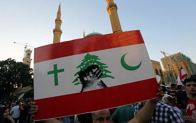 A Lebanese protester raises a placard during a mass rally against a political class seen as corrupt and incapable of providing basic services on August 29, 2015, at the iconic Martyrs Square in Beirut. (AFP PHOTO / STR) A Lebanese protester raises a placard during a mass rally against a political class seen as corrupt and incapable of providing basic services on August 29, 2015, at the iconic Martyrs Square in Beirut. (AFP PHOTO / STR)