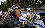 Women dance with an Israeli flag during "Tel Aviv Sur Seine", a beach event celebrating Tel Aviv, in central Paris on August 13, 2015.  (AFP PHOTO / KENZO TRIBOUILLARD)