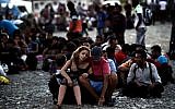 A Syrian couple waits with other migrants for the train near a train station at the F.Y.R. of Macedonia's village of Gevgelija on August 29, 2015. (AFP PHOTO / ARIS MESSINIS)