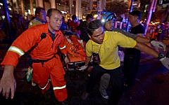 Thai rescue workers carry an injured person after a bomb exploded outside a religious shrine in central Bangkok late on August 17, 2015. (AFP Photo/Pornchai Kittiwongsakul)