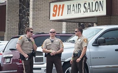 Police stand guard outside the 911 Hair Salon which was looted during a demonstration to mark the first anniversary of the shooting of Michael Brown on August 10, 2015 in Ferguson, Missouri (Scott Olson/Getty Images/AFP)