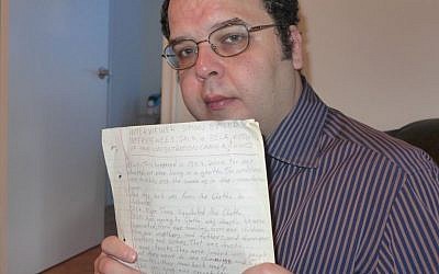 Simon Butler holds a rediscovered transcript of an interview he conducted for a seventh grade history class with two Holocaust survivors, Jack and Bella Bajnon, on July 29, 2015. (Trudi Cohen)