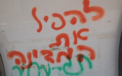 Graffiti at a bus stop in Yitzhar says "overthrow the government" and "price tag," on August 7, 2015. (Simona Weinglass) Graffiti at a bus stop in Yitzhar says "overthrow the government" and "price tag," on August 7, 2015. (Simona Weinglass)