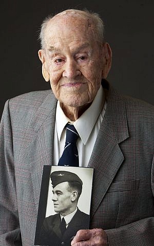 In this June 23, 2015 photo provided by Gordon Royle, his father Paul Royle poses for a photo holding a picture of himself in uniform during World War ll, in Perth, Australia.  (Garry Sarre/Gordon Royle via AP)