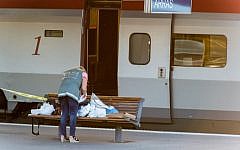 A police officer works on a platform near a Thalys train of French national railway operator, SNCF, at the main train station in Arras, northern France, after a gunman opened fire injuring three passengers, Friday, Aug. 21, 2015. (AP Photo)