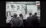 In this screenshot, Israel residents read propaganda posters during the 1949 election campaign (Photo courtesy AP)