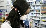 Worker at a Jerusalem pharmacy (Abir Sultan/Flash90)