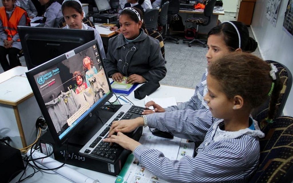 Palestinian schoolgirls sit inside their classroom during the opening ceremony of a school in Khuza'a, east of Khan Younis, in the southern Gaza Strip, March 22, 2015. (Abed Rahim Khatib/Flash90)