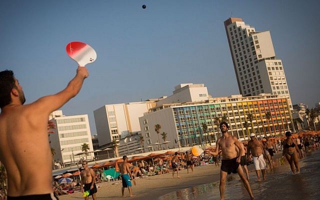 People play beach tennis (matkot), on the beach in the Israeli coastal city of Tel Aviv, on a hot summer day. August 01, 2015. (Miriam Alster/FLASH90)