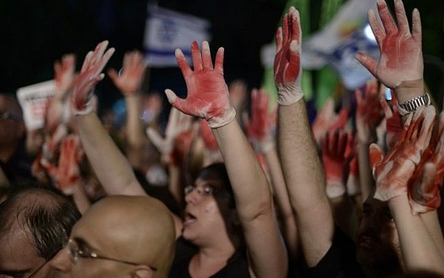 Demonstrators hold up hands painted in red to signify blood while protesting an address by Likud minister Yuval Steinitz at an anti-violence and anti-homophobia rally in Tel Aviv, on August 01, 2015. (Tomer Neuberg/Flash90) Demonstrators hold up hands painted in red to signify blood while protesting an address by Likud minister Yuval Steinitz at an anti-violence and anti-homophobia rally in Tel Aviv, on August 01, 2015. (Tomer Neuberg/Flash90)