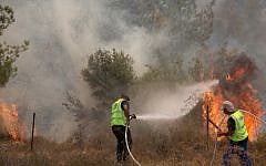 Illustrative: Israel Nature and Parks Authority workers try to extinguish a brush fire near Moshav Even Sapir, just outside of Jerusalem, on August 2, 2015. (Yonatan Sindel/Flash90)