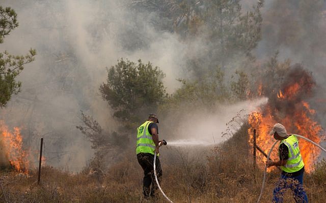 Illustrative: Israel Nature and Parks Authority workers try to extinguish a brush fire near Moshav Even Sapir, just outside of Jerusalem, on August 2, 2015. (Yonatan Sindel/Flash90) Illustrative: Israel Nature and Parks Authority workers try to extinguish a brush fire near Moshav Even Sapir, just outside of Jerusalem, on August 2, 2015. (Yonatan Sindel/Flash90)