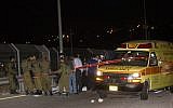Israeli security forces stand by the body of a Palestinian man who was shot after stabbing an Israeli on Sunday night, August 9, 2015, at a gas station on the 443 road to Jerusalem (Yonatan Sindel/Flash90)