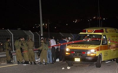 Israeli security forces stand by the body of a Palestinian man who was shot after stabbing an Israeli on Sunday night, August 9, 2015, at a gas station on the 443 road to Jerusalem (Yonatan Sindel/Flash90)