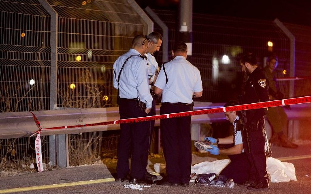 Israeli security forces stand by the body of the terrorist who stabbed an Israeli at the Route 443 gas station, near Jerusalem, August 9, 2015. (Yonatan Sindel/Flash90)