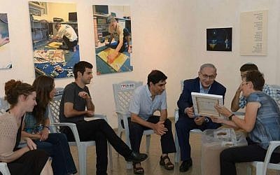 Prime Minister Benjamin Netanyahu visits an exhibition of paintings by the late Hadar Goldin, killed in battle in Gaza with his body never recovered, at the artists' village Ein Hod in northern Israel, on August 10, 2015. (Amos Ben Gershom/GPO)