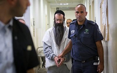 Accused Jerusalem Gay Pride Parade attacker Yishai Schlissel is escorted by police after his hearing at the Jerusalem District Court on August 11, 2015. (Miriam Alster/Flash90)