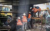A crew works on Tel Aviv's partly destroyed Maariv bridge -- which was completely demolished on August 21 -- on August 19, 2015. (Flash90)