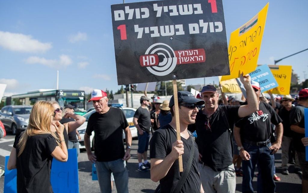 Israel Broadcast Authority employees holds signs as they protest against planned dismissals in Jerusalem on August 30, 2015 (Yonatan Sindel/Flash90)