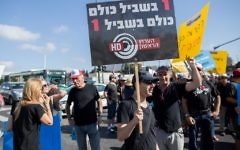 Israel Broadcast Authority employees holds signs as they protest against planned dismissals in Jerusalem on August 30, 2015 (Yonatan Sindel/Flash90)