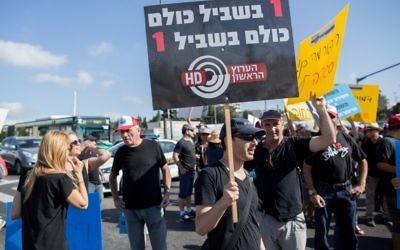 Israel Broadcast Authority employees holds signs as they protest against planned dismissals in Jerusalem on August 30, 2015 (Yonatan Sindel/Flash90)