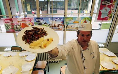 In this May 6, 2014 file photo, French chef Xavier Lebeau poses with a plate of Quenelles de Brochet (pike fish) with Green Haricot beans and Champignons de Paris (Paris mushrooms), at the Saint Pierre de Chaillot school in Paris, France. France has been grappling with how to reconcile religious beliefs with secular values when it comes to pork in school lunches, with one lawmaker’s solution: vegetarian meals. (AP Photo/Francois Mori, File)
