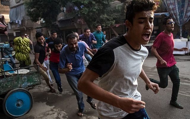In this Tuesday, June 30, 2015 photo, protesters affiliated with the Muslim Brotherhood run in fear of Egyptian police forces opening fire towards them during a protest on the second anniversary of the ouster of Islamist President Mohammed Morsi in the Matariya district of Cairo. (AP Photo/Belal Darder) 