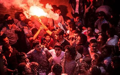 In this Tuesday, June 23, 2015, members of Ultras Nahdawy, a youth group of the Muslim Brotherhood, sing anti-army chants in a protest ahead of the second anniversary of the ouster of Islamist President Mohammed Morsi in the Nahia district, near Cairo, Egypt. (AP Photo/Belal Darder)